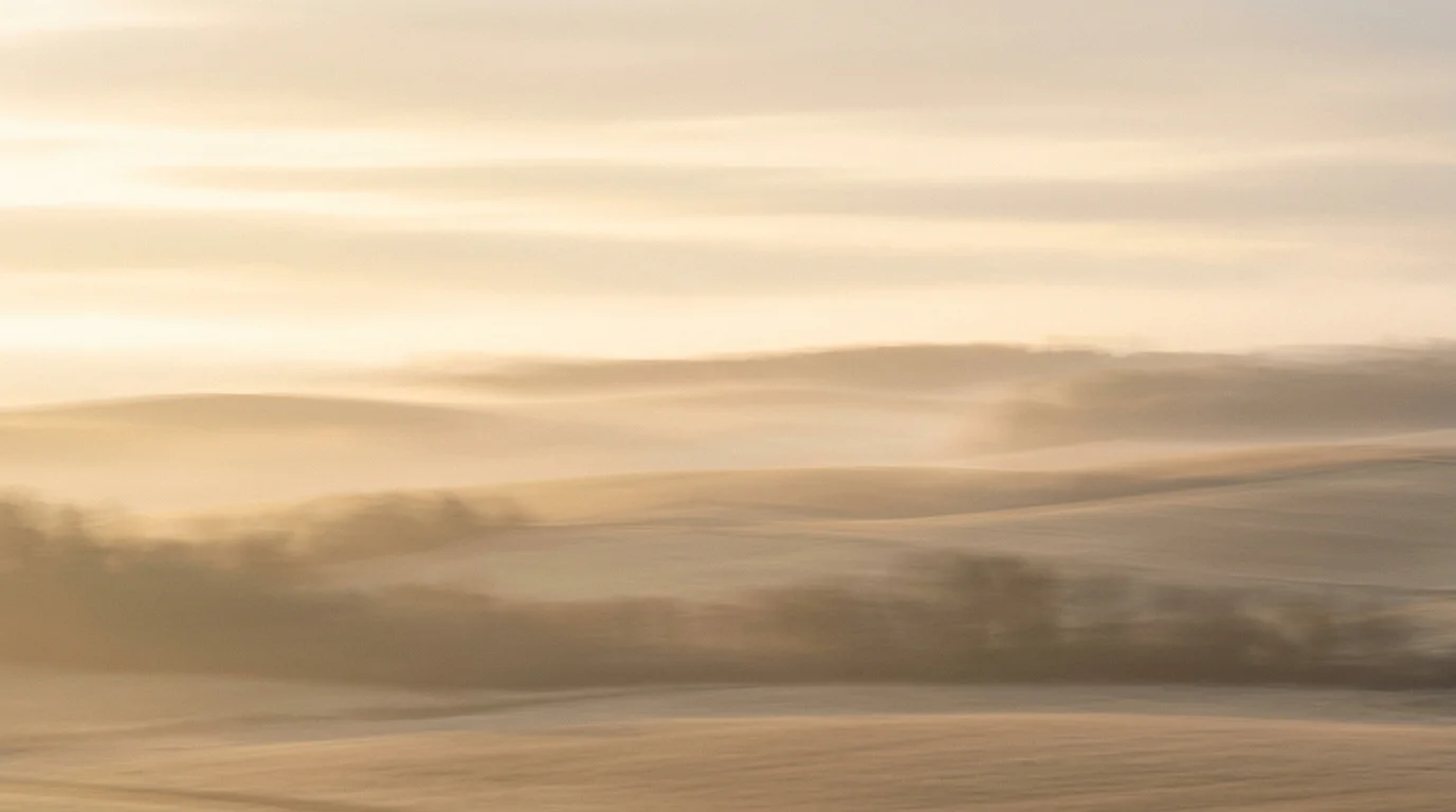 A still, calm frame of rolling hills at dusk